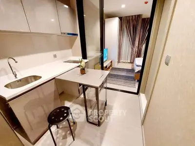 Modern compact kitchen with sleek design and open layout leading to cozy bedroom.
