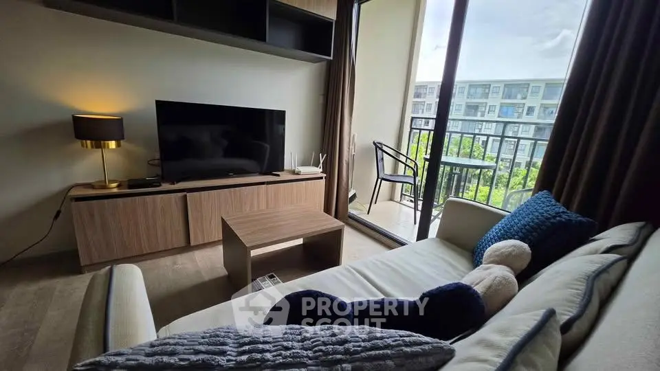 Modern living room with balcony view, stylish decor, and natural light.