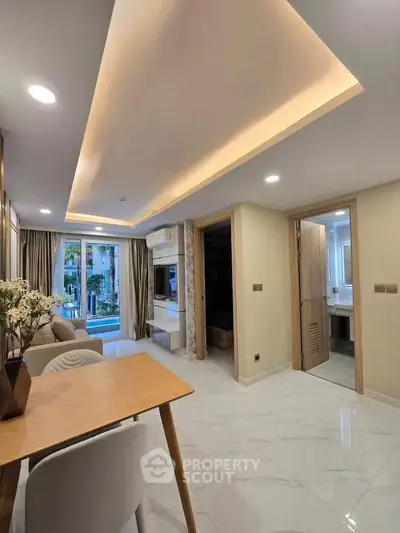 Modern living room with elegant ceiling lights and garden view, featuring stylish furniture and open layout.
