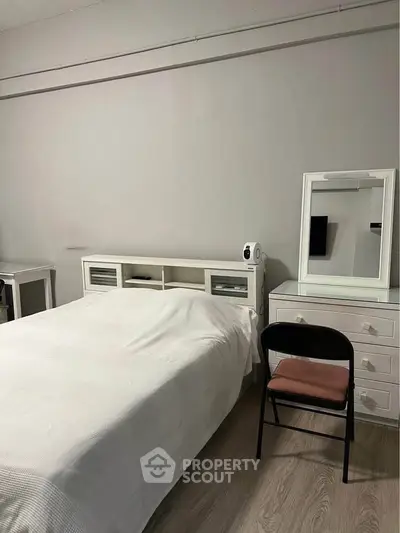Cozy bedroom with white furniture and minimalist decor, perfect for relaxation and comfort.