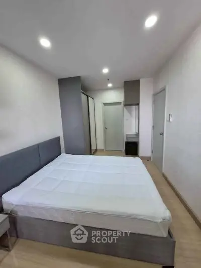 Modern bedroom with sleek design and ample storage in a contemporary apartment.