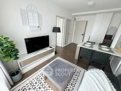 Modern living room with stylish decor, TV, and dining area in open layout apartment.