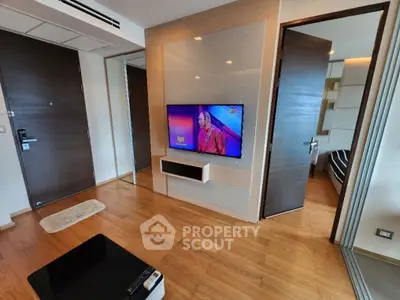 Modern living room with wall-mounted TV and sleek wooden flooring