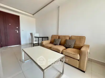 Modern living room with beige sofa and sleek white coffee table in a bright apartment.
