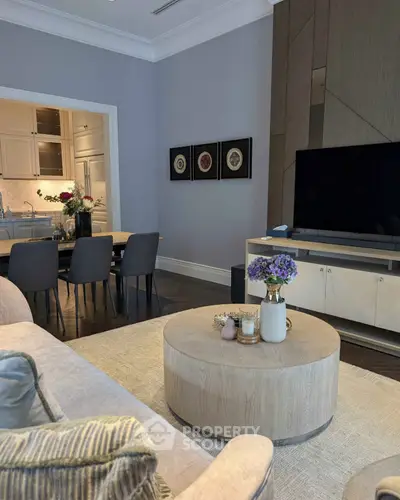 Elegant living room with modern decor and open kitchen layout, featuring stylish furniture and a cozy atmosphere.