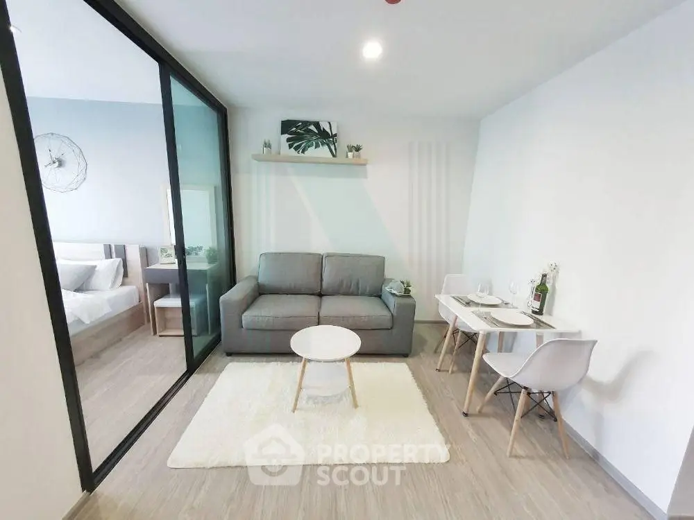 Modern living room with cozy sofa and dining area in open-plan apartment.