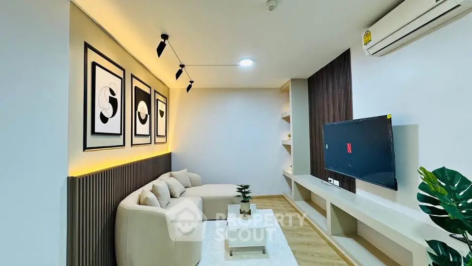 Modern living room with stylish decor, cozy sofa, and wall-mounted TV, perfect for relaxation and entertainment.