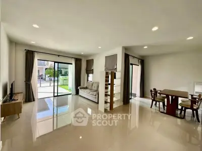 Spacious modern living room with large windows and elegant dining area