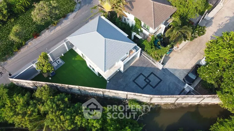 Aerial view of modern house with spacious driveway and lush greenery