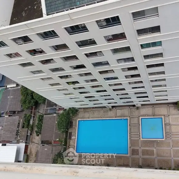 High-rise building with pool view from above, showcasing urban living amenities.