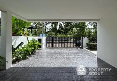 Spacious modern driveway with lush greenery and secure gate