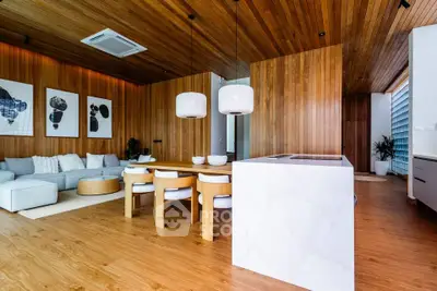 Luxurious modern living room with wooden accents and open layout, featuring stylish furniture and elegant lighting.
