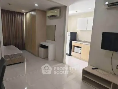Modern studio apartment with open layout, featuring a compact kitchen and cozy living area.