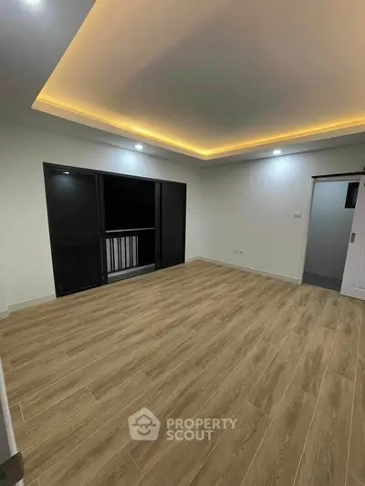 Spacious modern living room with wooden flooring and ambient lighting