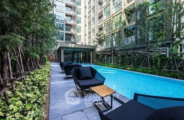 Luxurious apartment complex with modern poolside seating and lush greenery