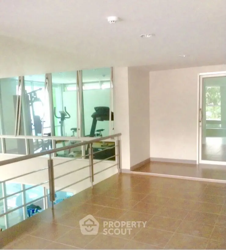 Spacious gym area with modern equipment and large windows