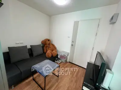 Cozy living room with modern sofa and wooden flooring, perfect for relaxation.