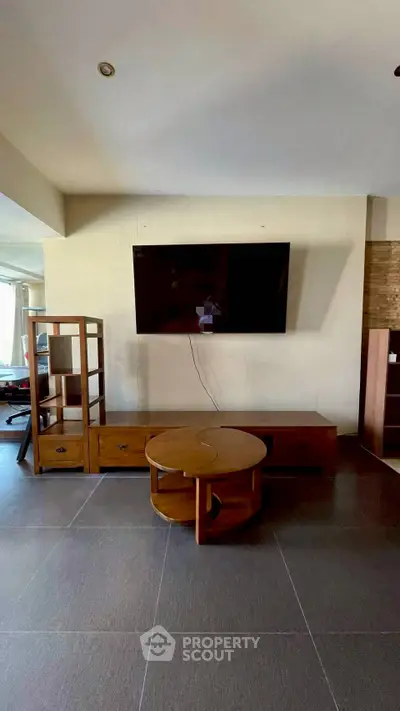 Spacious living room with modern TV setup and stylish wooden furniture