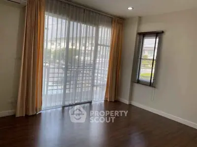 Spacious living room with large windows and wooden flooring, perfect for natural light lovers.
