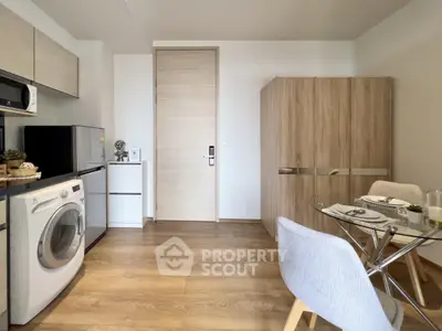 Modern kitchen with washing machine and dining area in cozy apartment