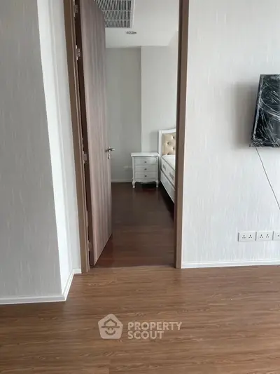 Modern bedroom entrance with wooden flooring and sleek design