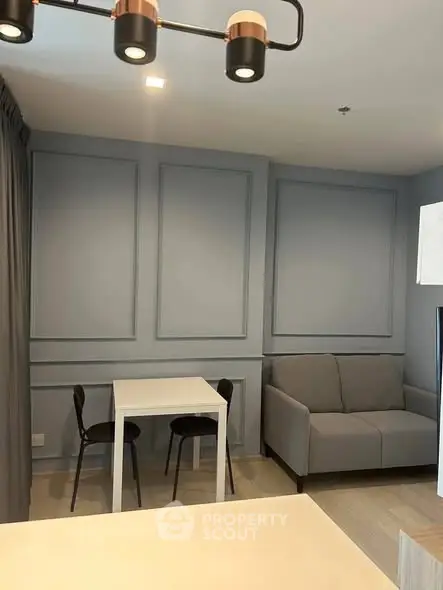 Modern living room with stylish gray sofa and dining area