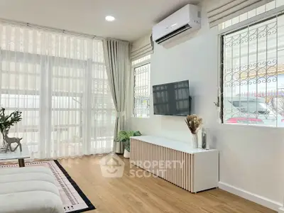 Modern living room with large windows, air conditioning, and stylish decor