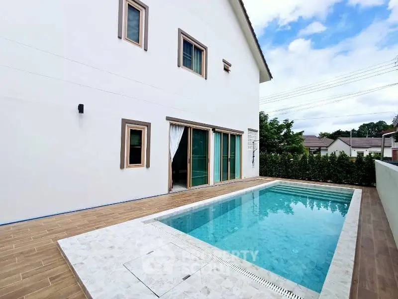 Modern home exterior with private pool and elegant patio area.