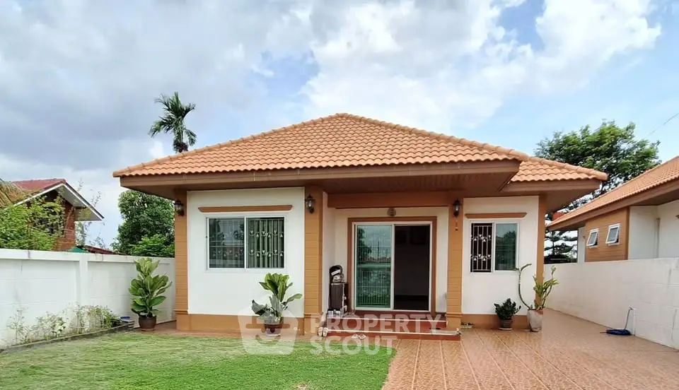 Charming single-story home with tiled roof and lush garden, perfect for serene living.