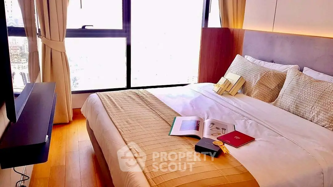 Luxurious bedroom with large window and elegant decor in modern apartment.