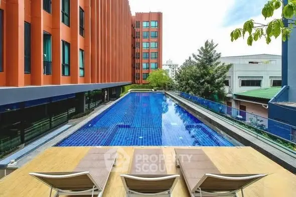 Luxurious modern apartment complex with stunning outdoor pool and sun loungers.