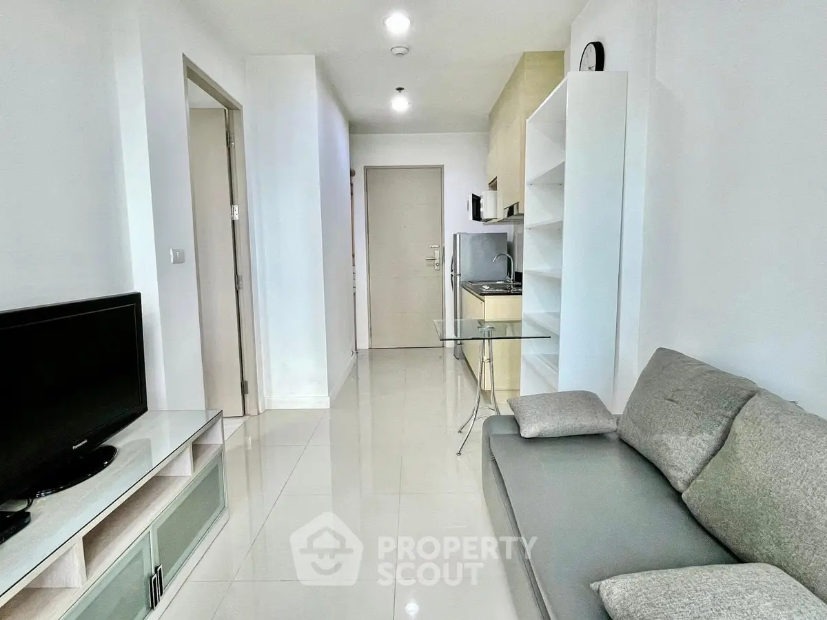 Modern living room with sleek furniture and minimalist design, featuring a cozy sofa and entertainment center.