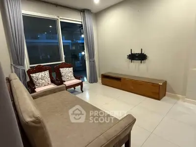 Spacious living room with elegant furniture and large window for natural light.