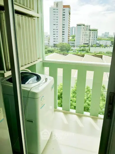 Charming balcony with washing machine and city view, perfect for urban living convenience.