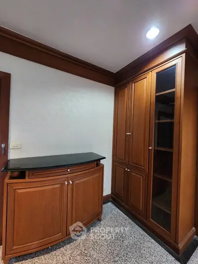 Elegant wooden storage cabinets in a modern interior space with ambient lighting.