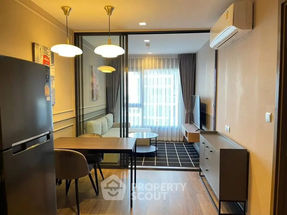 Modern living room with dining area, stylish furniture, and air conditioning in a cozy apartment.