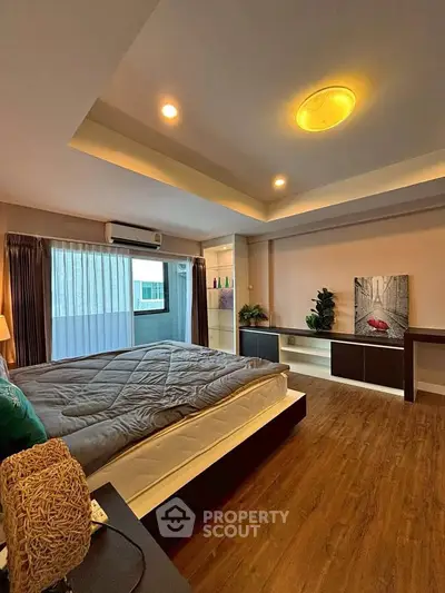 Spacious modern bedroom with elegant lighting and wooden flooring