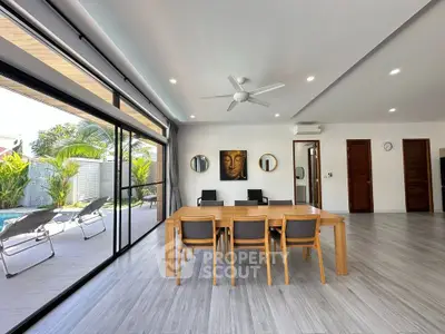 Spacious modern living room with pool view and elegant dining area