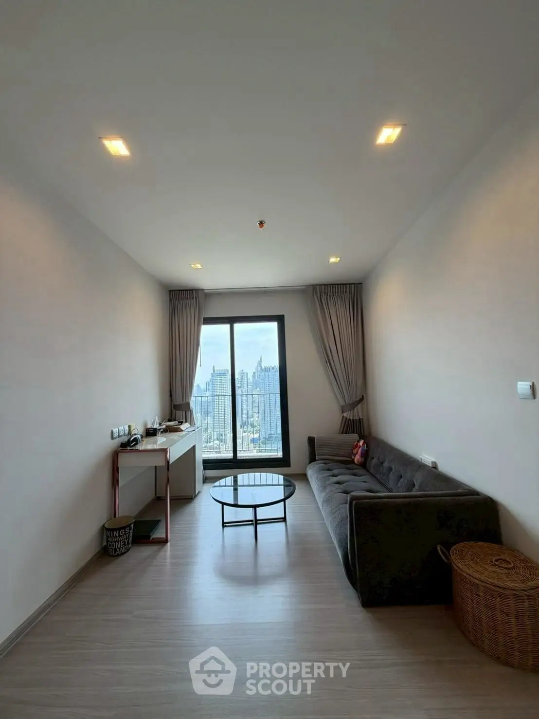 Modern living room with city view, sleek furniture, and natural light.