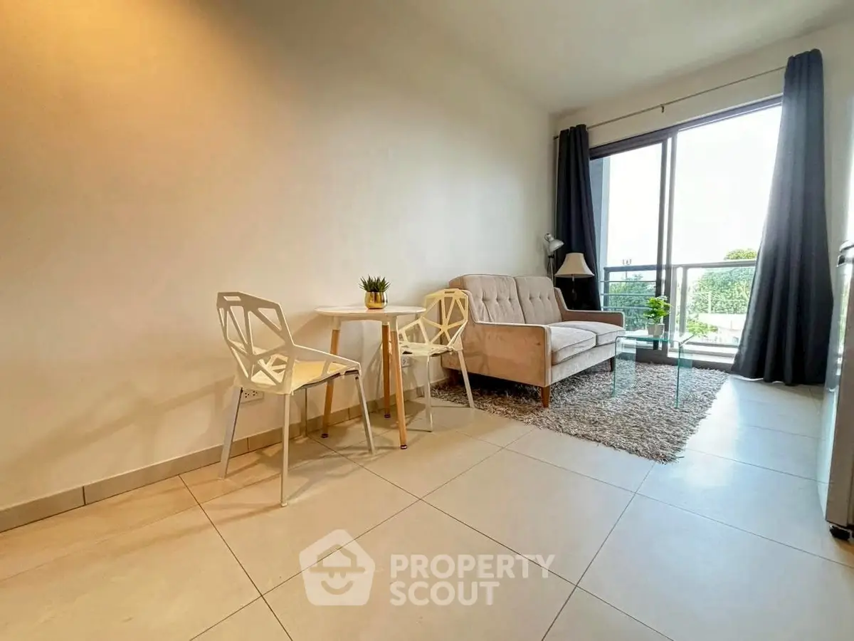 Modern living room with stylish furniture and large window offering natural light and garden view.