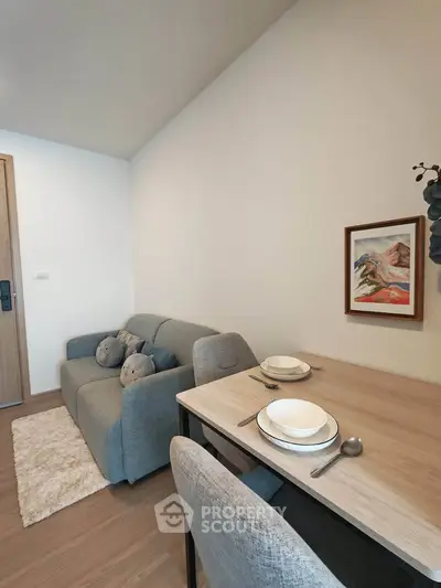 Cozy living room with modern decor and dining area in a stylish apartment.