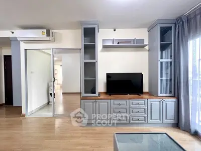 Spacious living room with modern built-in cabinets and sleek wooden flooring.