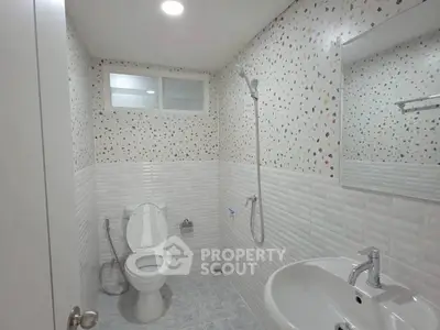 Modern bathroom with terrazzo wall tiles and sleek fixtures