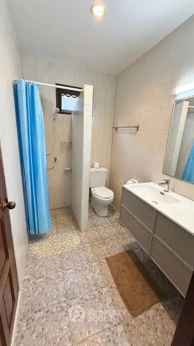 Spacious bathroom with modern fixtures and a shower area, perfect for comfort and convenience.
