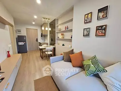 Modern living room with cozy sofa, stylish decor, and open kitchen layout in a contemporary apartment.