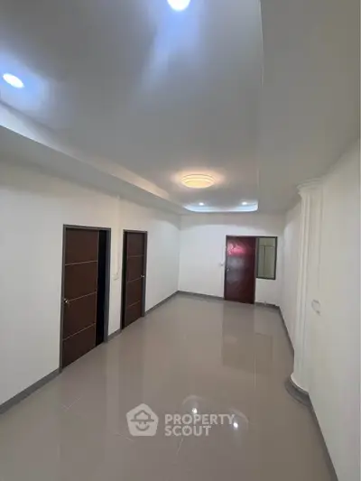 Spacious hallway with modern lighting and sleek tile flooring in a contemporary home.