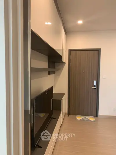 Modern apartment entrance with sleek storage and TV unit