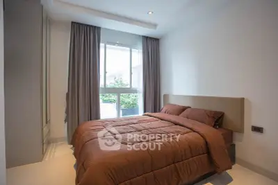 Cozy bedroom with modern decor and large window for natural light.
