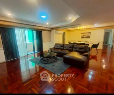 Spacious living room with elegant hardwood floors and modern furniture, perfect for entertaining guests.