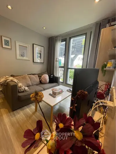 Cozy living room with modern decor and large windows offering natural light.
